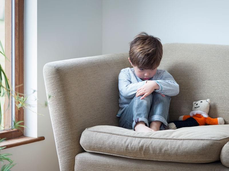 Niño enojado sentado en el sofá