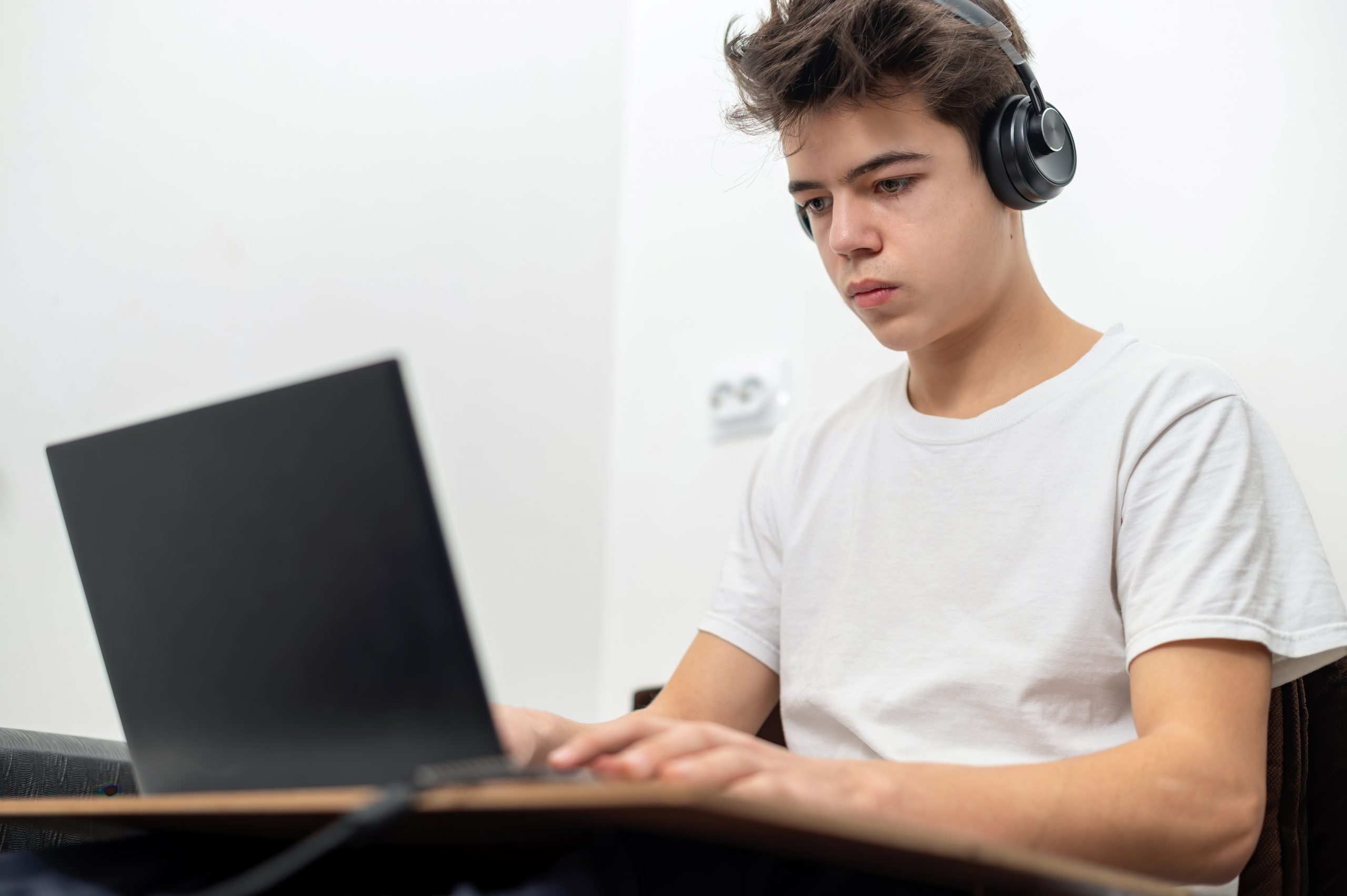 Adolescente con audífonos utilizando notebook